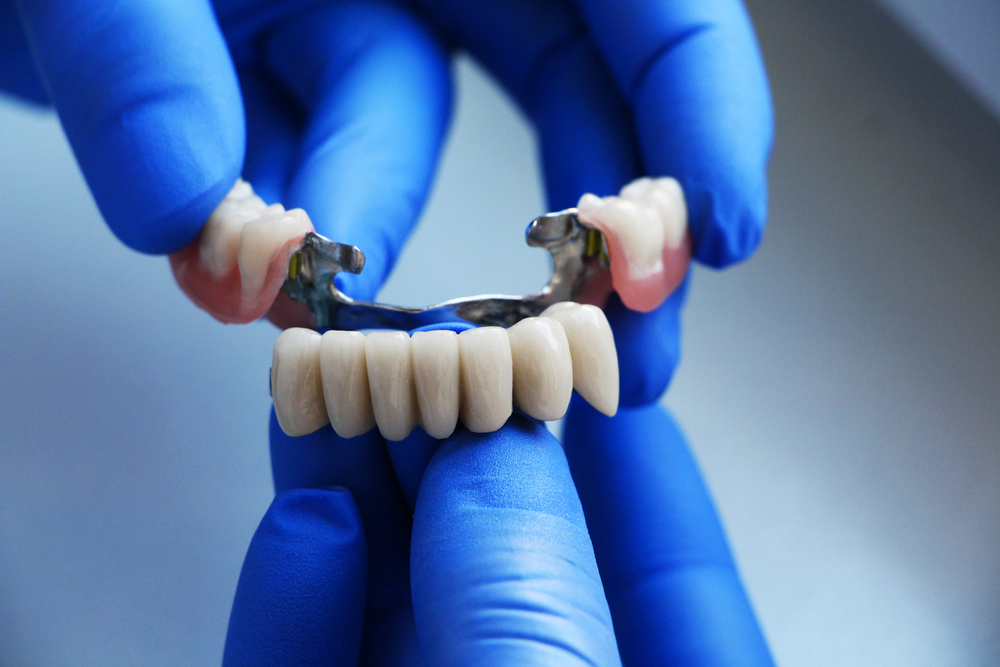 dentist holding a dental bridge